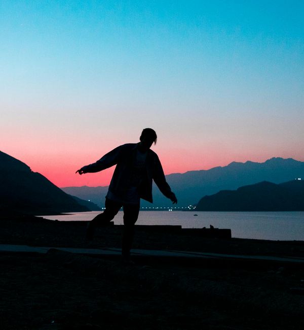 Person in a calm, balanced pose against a minimalist background.